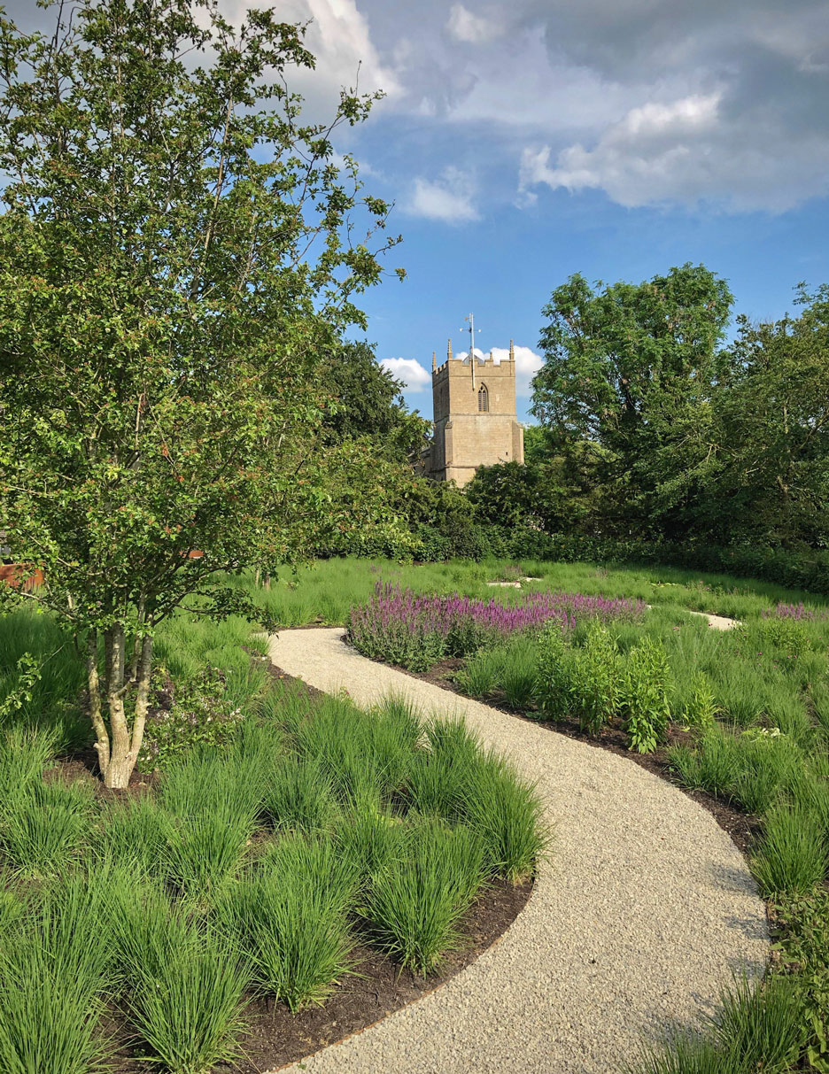 Cambridgeshire Garden designer ornamental perennial meadow and winding gravel path to church view designed by Colm Joseph