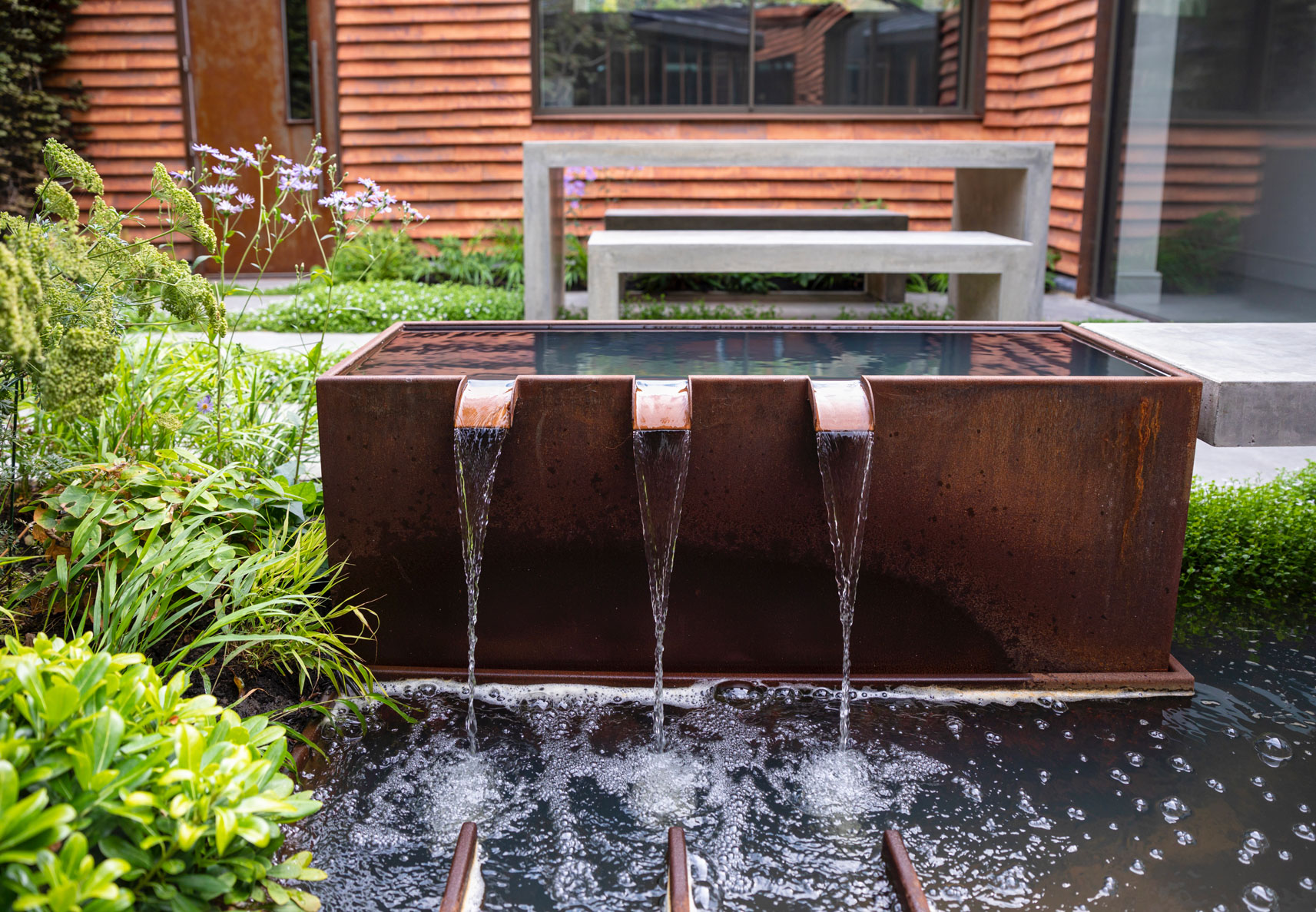 Colm Joseph garden design Cambridge courtyard modern house concrete paving corten steel water feature concrete table and benches